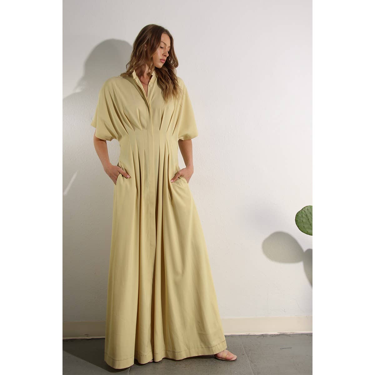 Lifestyle photo of North and Five's Butter Yellow Long Button-Down Dress with model tilting head down.