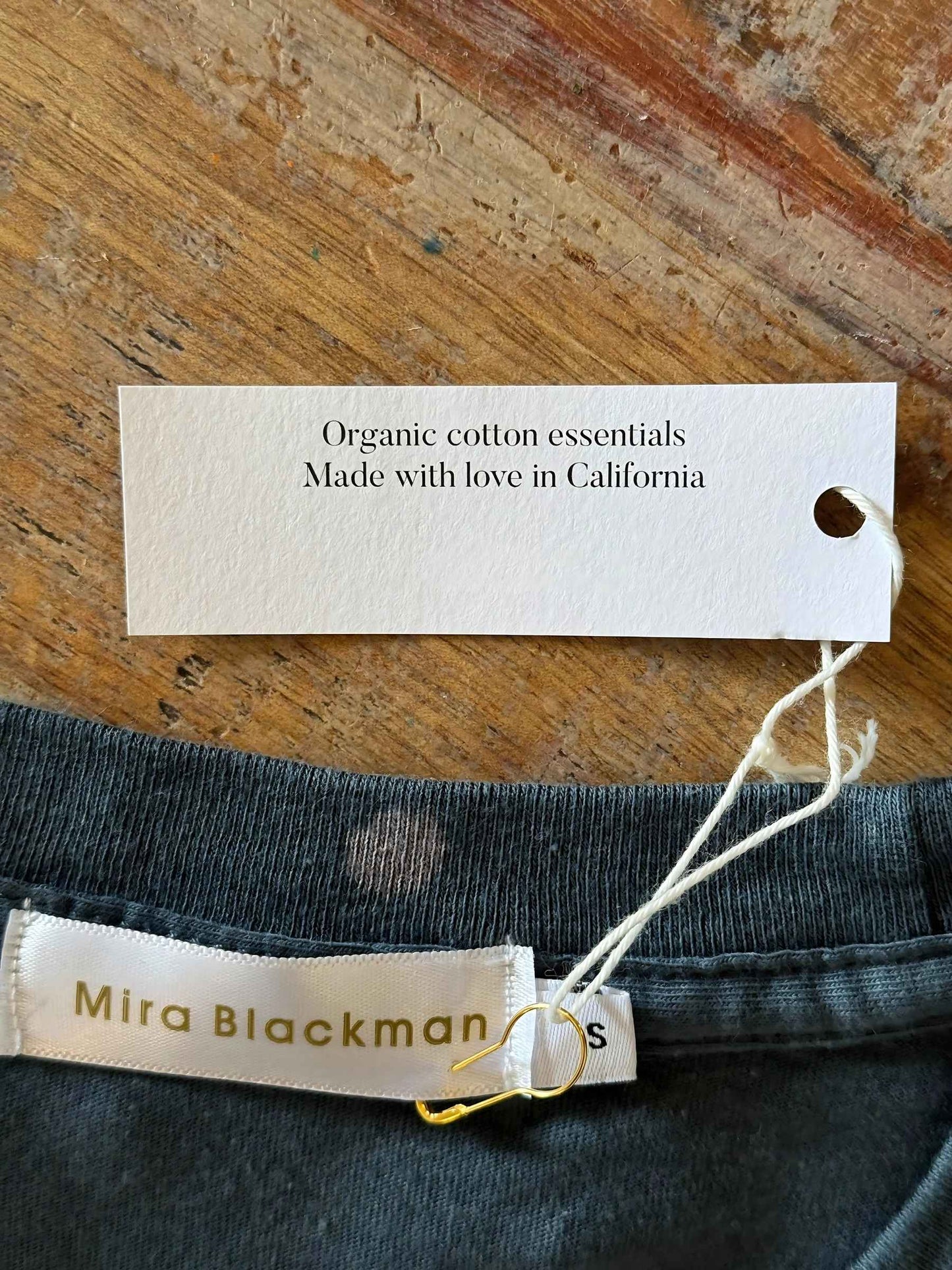 close up of Luminary Organic Tee by Mira Blackman in slate and showing organic cotton and made with love in California.