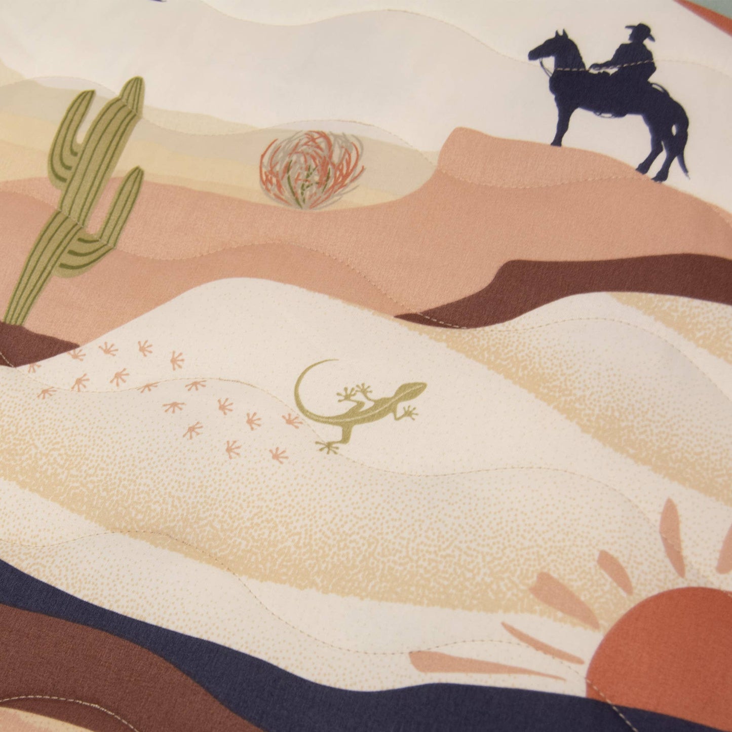 Close up of North and Five Journey Throw, showing cowboy, cactus and sun design.