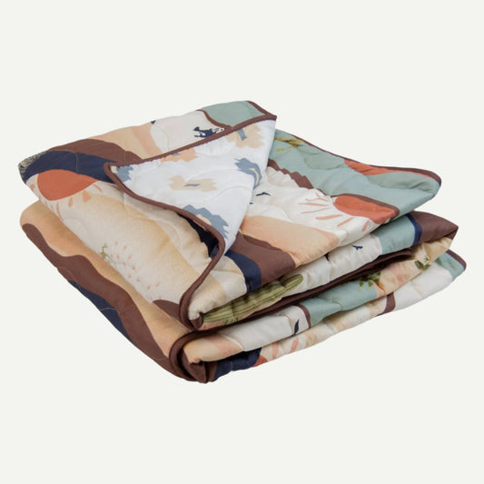 Folded Journey Throw with Earth-toned cowboy, cactus and sun design.