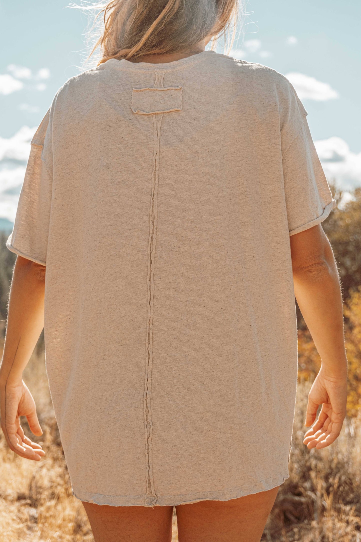Full back view of Hemp Organic Cotton Unisex T-Shirt. Model's long blonde hair swept to side.