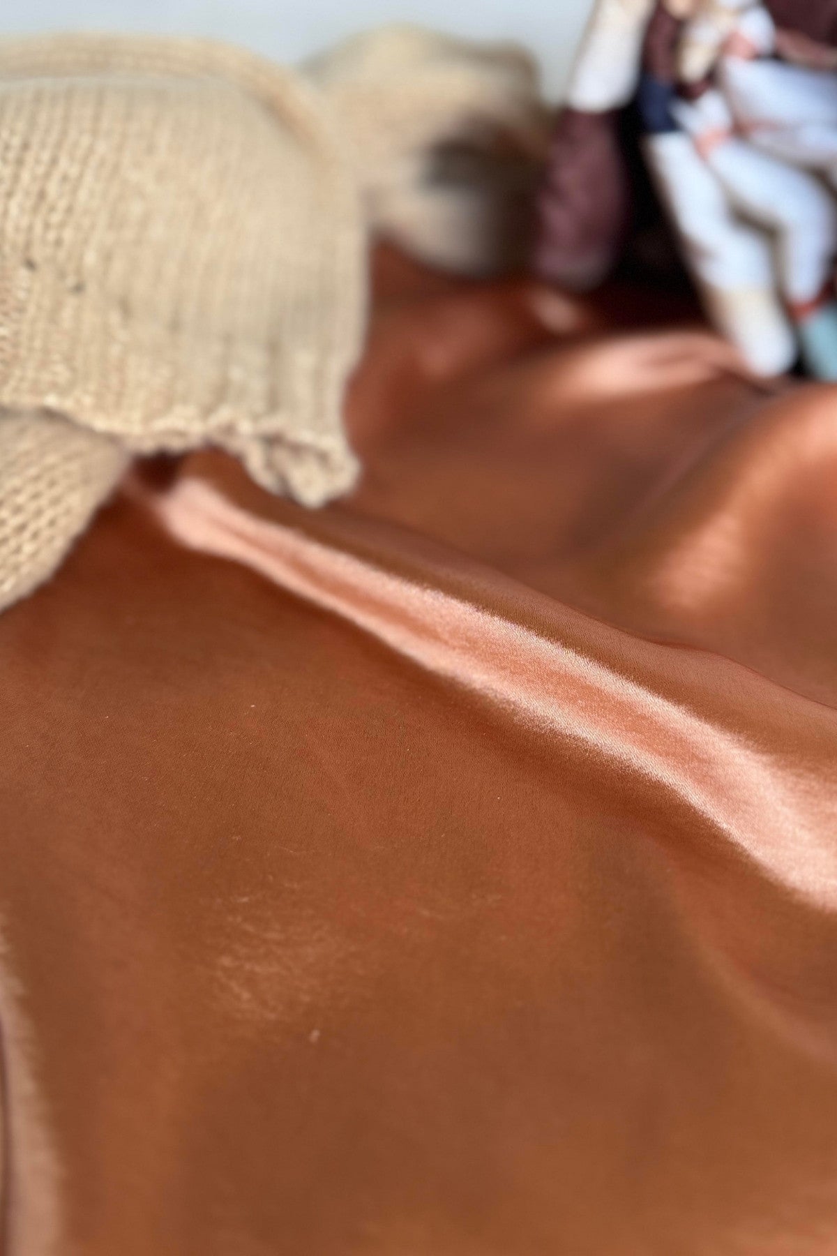 Close up of Golden Hour Satin Maxi Skirt fabric and golden, pink color.
