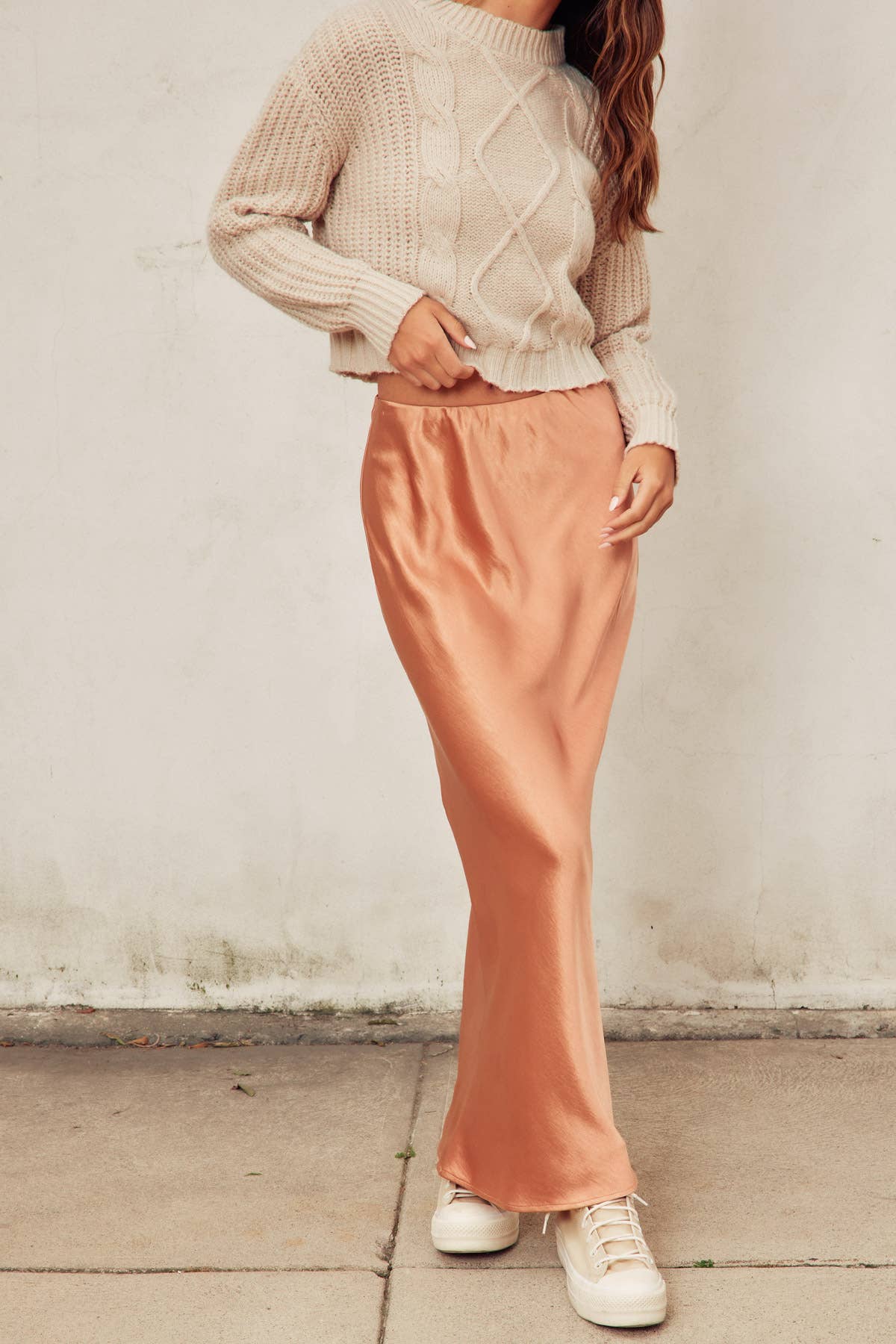 Flowing satin maxi skirt in a golden sunset hue, captured mid-movement in natural light.