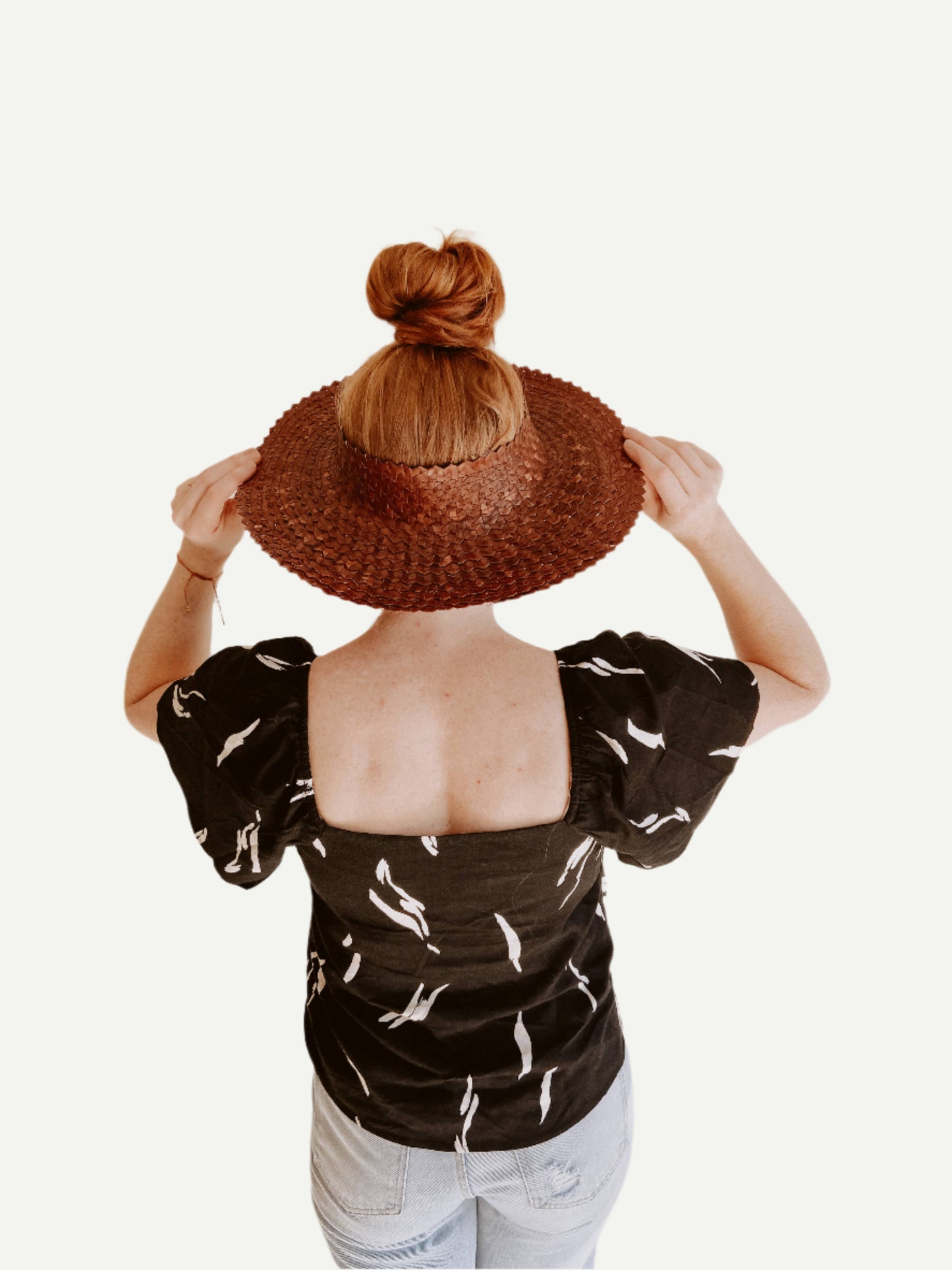 Back view of Papale Sun Hat in Clay. Styled with jeans and top.
