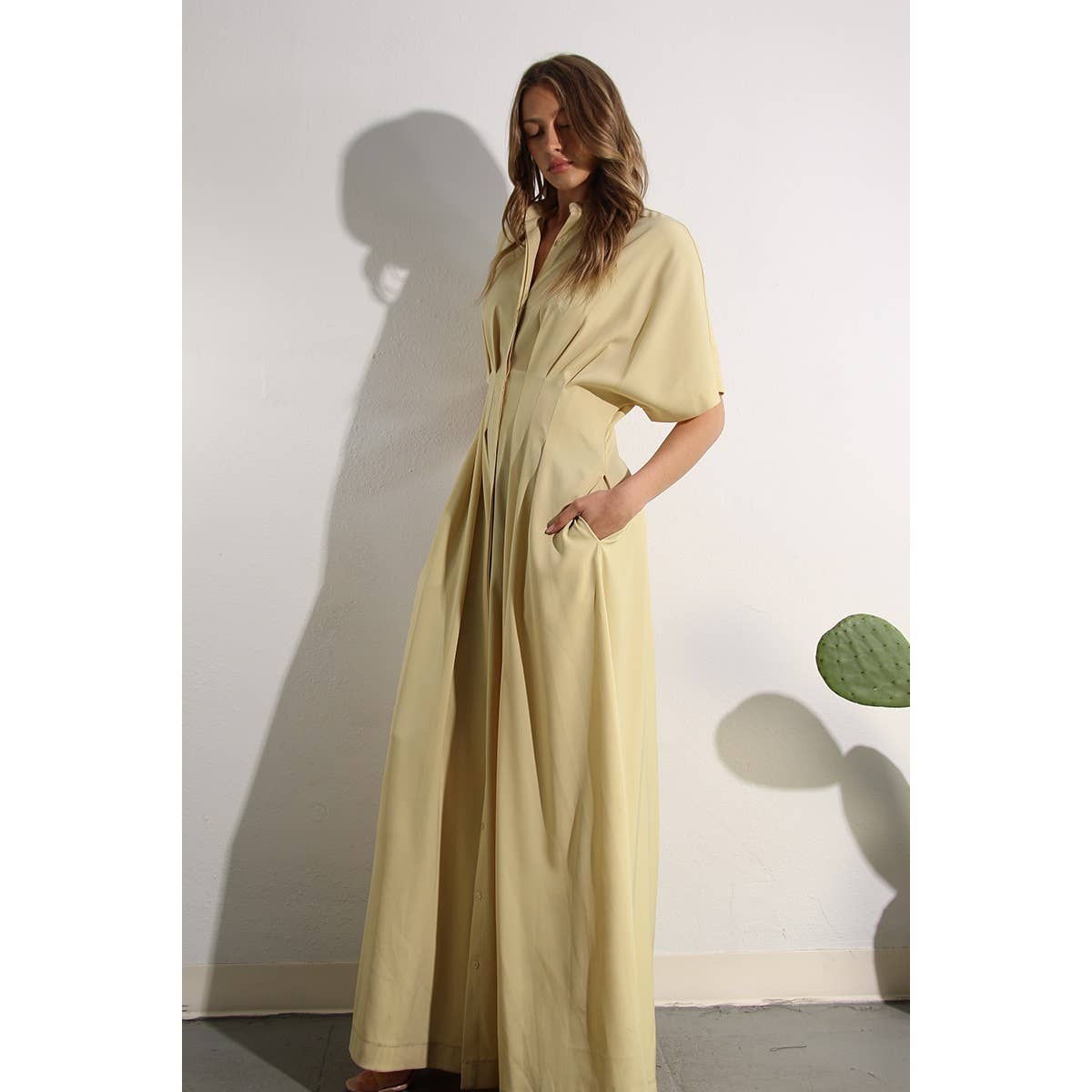 Lifestyle photo of North and Five's Butter Yellow Long Button-Down Dress with model showcasing pockets.