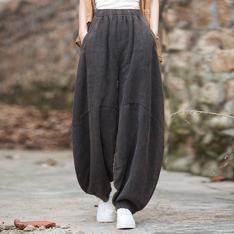 Black wide-leg lantern pants with a relaxed fit and natural fiber texture, paired with sneakers.