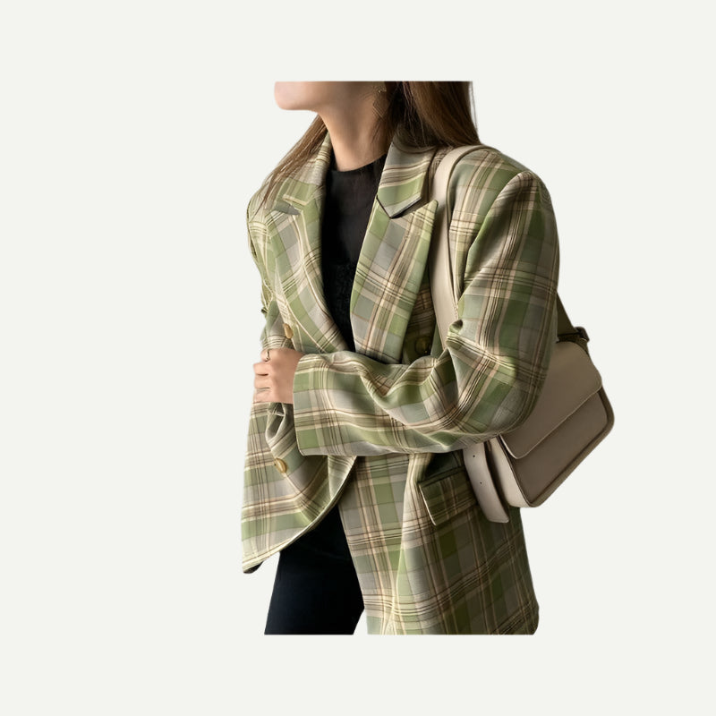 Sideview of oversized green tartan blazer and soft tailoring, styled with black T-shirt and black jeans.