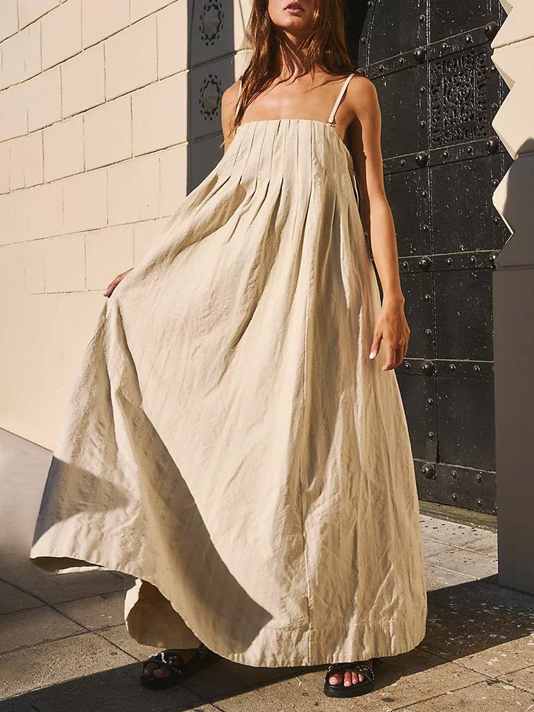 Oversized beige cotton swing dress with pleated front, styled for summer.