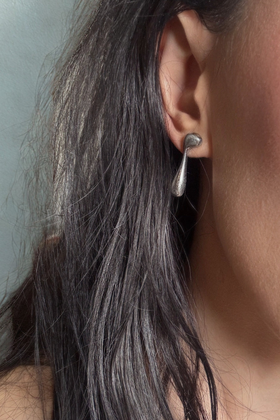 Close up of Vice Versa Stud on left ear of model with dark hair.