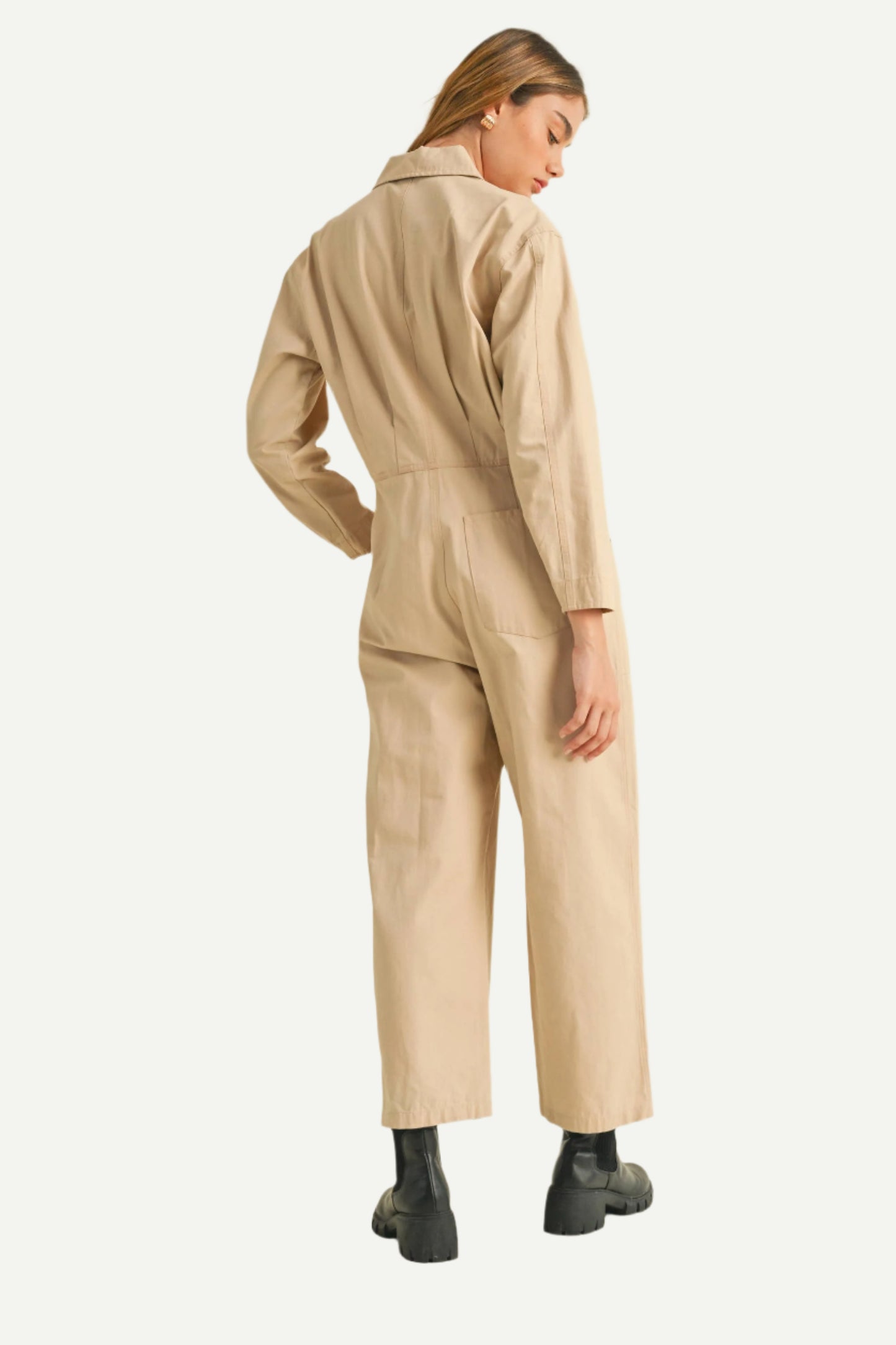 Back view of North and Five Dune Utility Jumpsuit on model, and styled with black boots. 