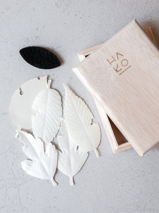 Closeup of HA KO Paper Incense – Wooden Box Set on white table.