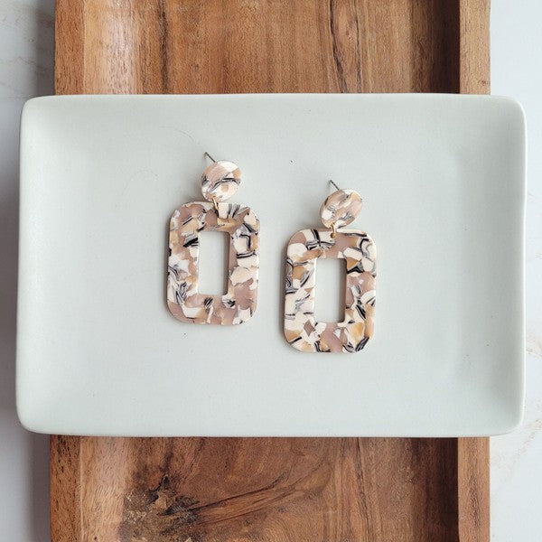 Handmade Sandstone Earrings on white plate balancing on wooden bowl.