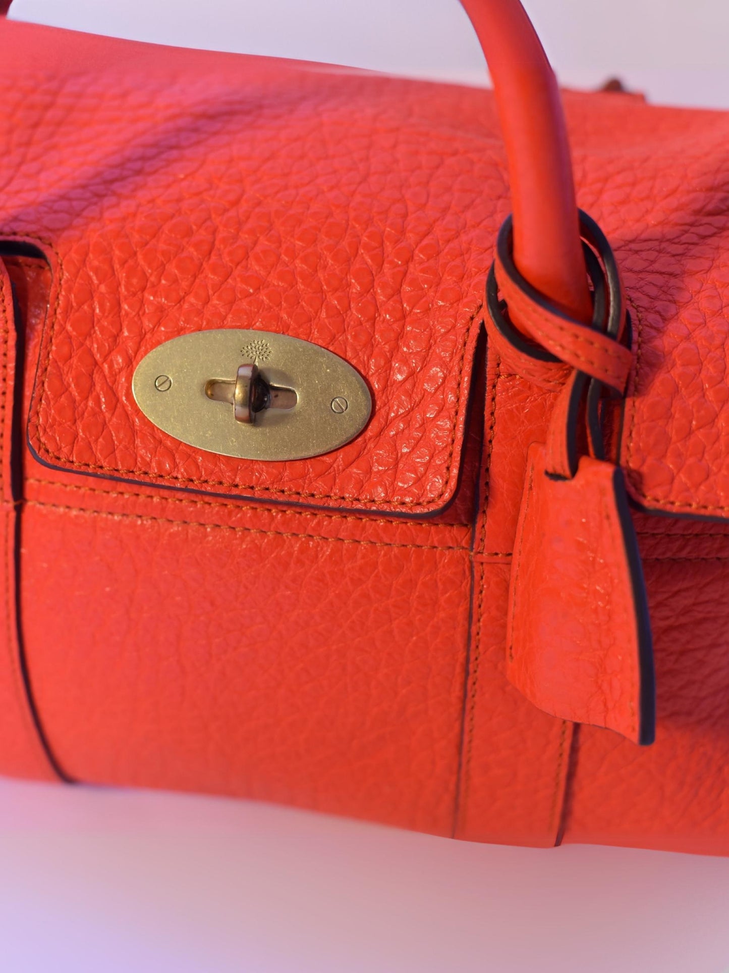 Close up of lock on coral orange Mulberry Bayswater leather bag 