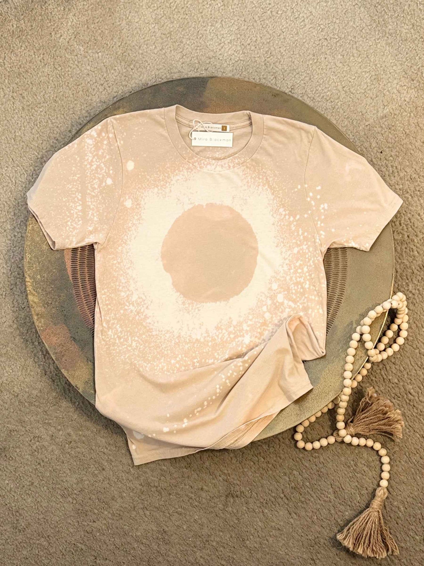 Flat lay of Neutral-toned hand-dyed organic t-shirt with a soft texture and minimalist style.