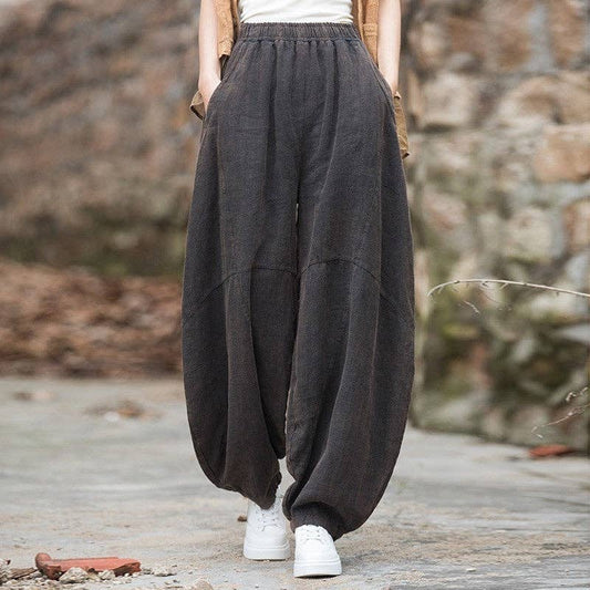 Black wide-leg lantern pants with a relaxed fit and natural fiber texture, paired with sneakers.