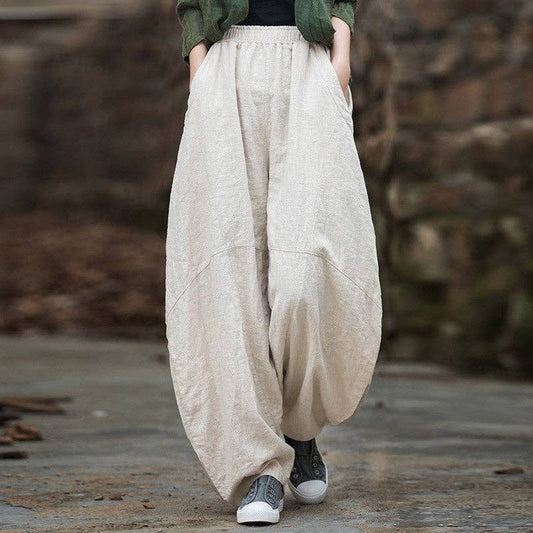Natural linen lantern pants with sand-washed finish and airy silhouette for casual styling.