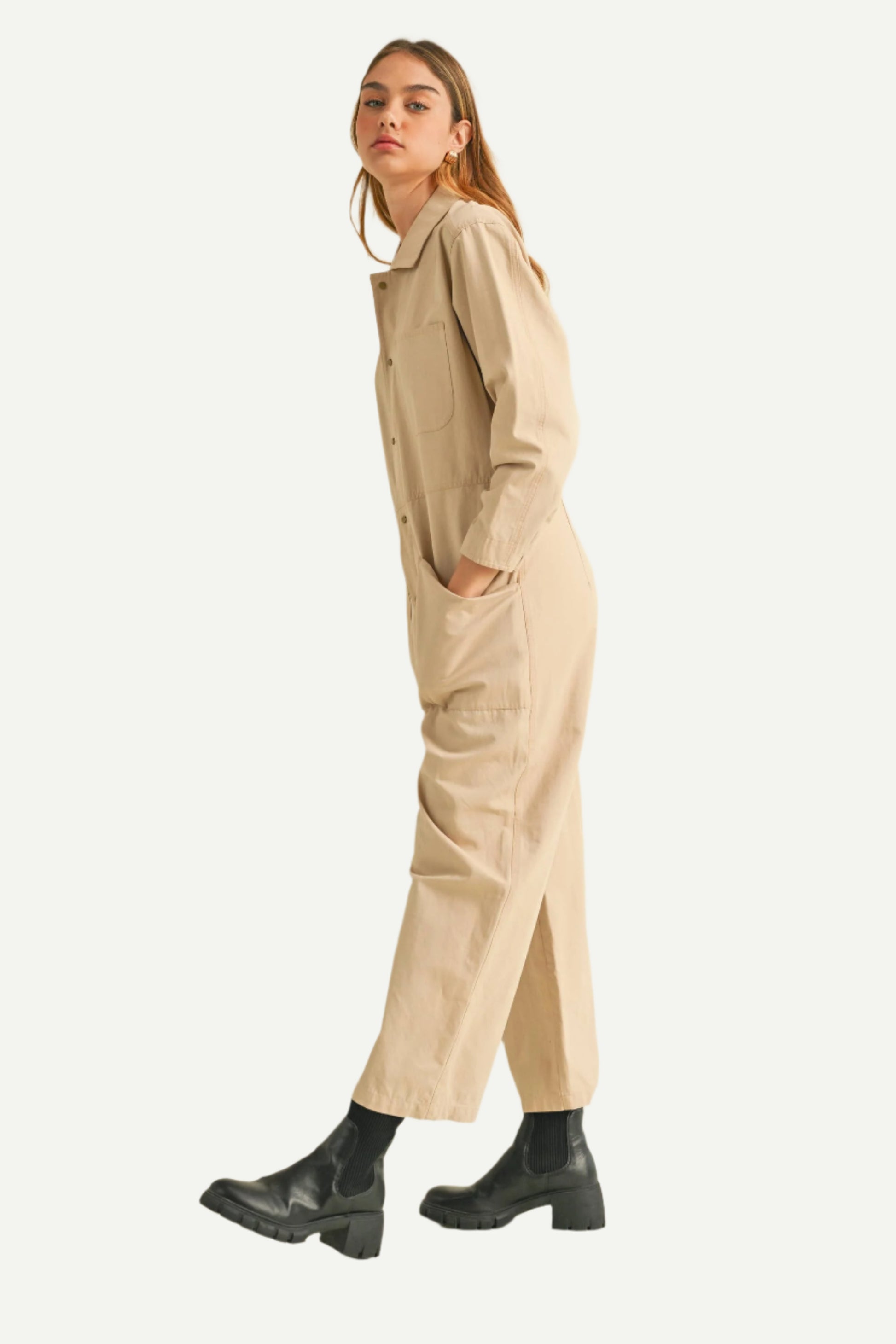 Side view of North and Five Dune Utility Jumpsuit and, styled with black boots
