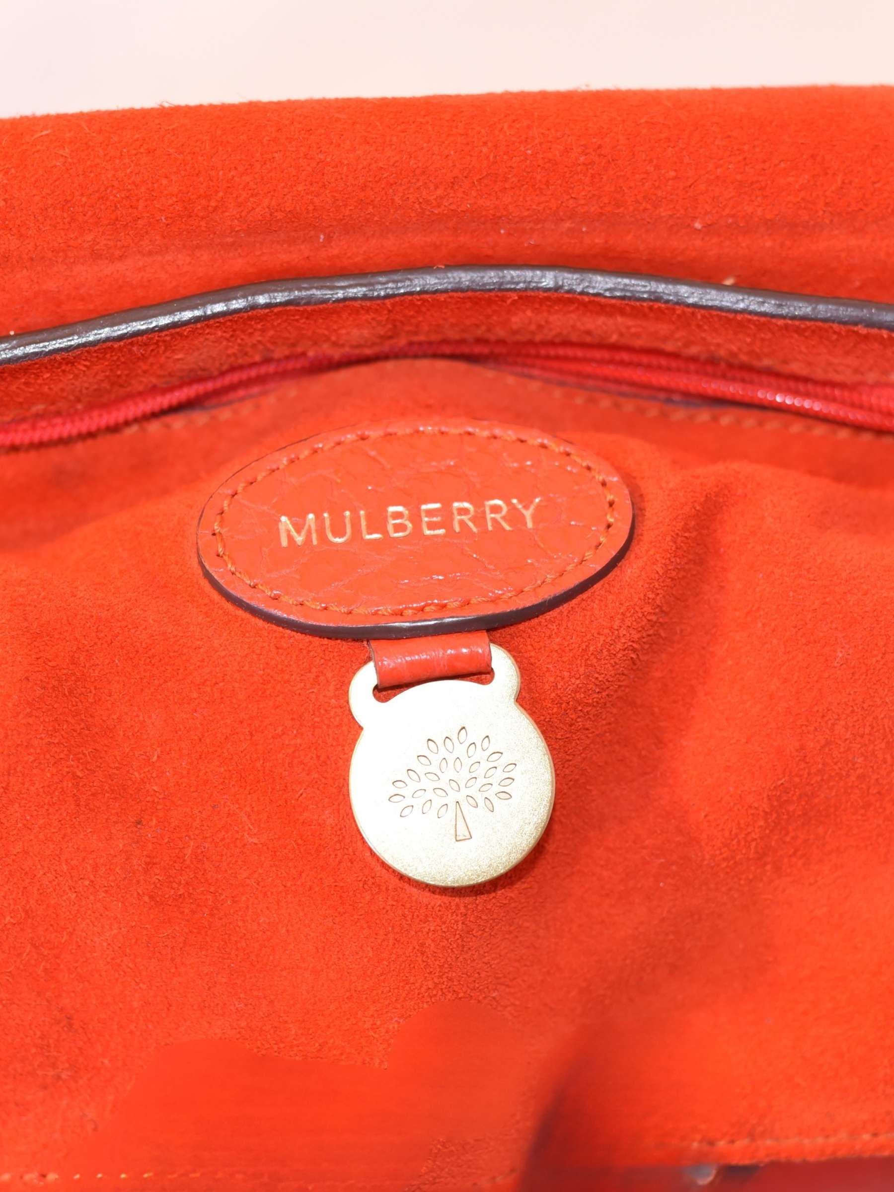 Close up of tag on coral orange Mulberry Bayswater leather bag 