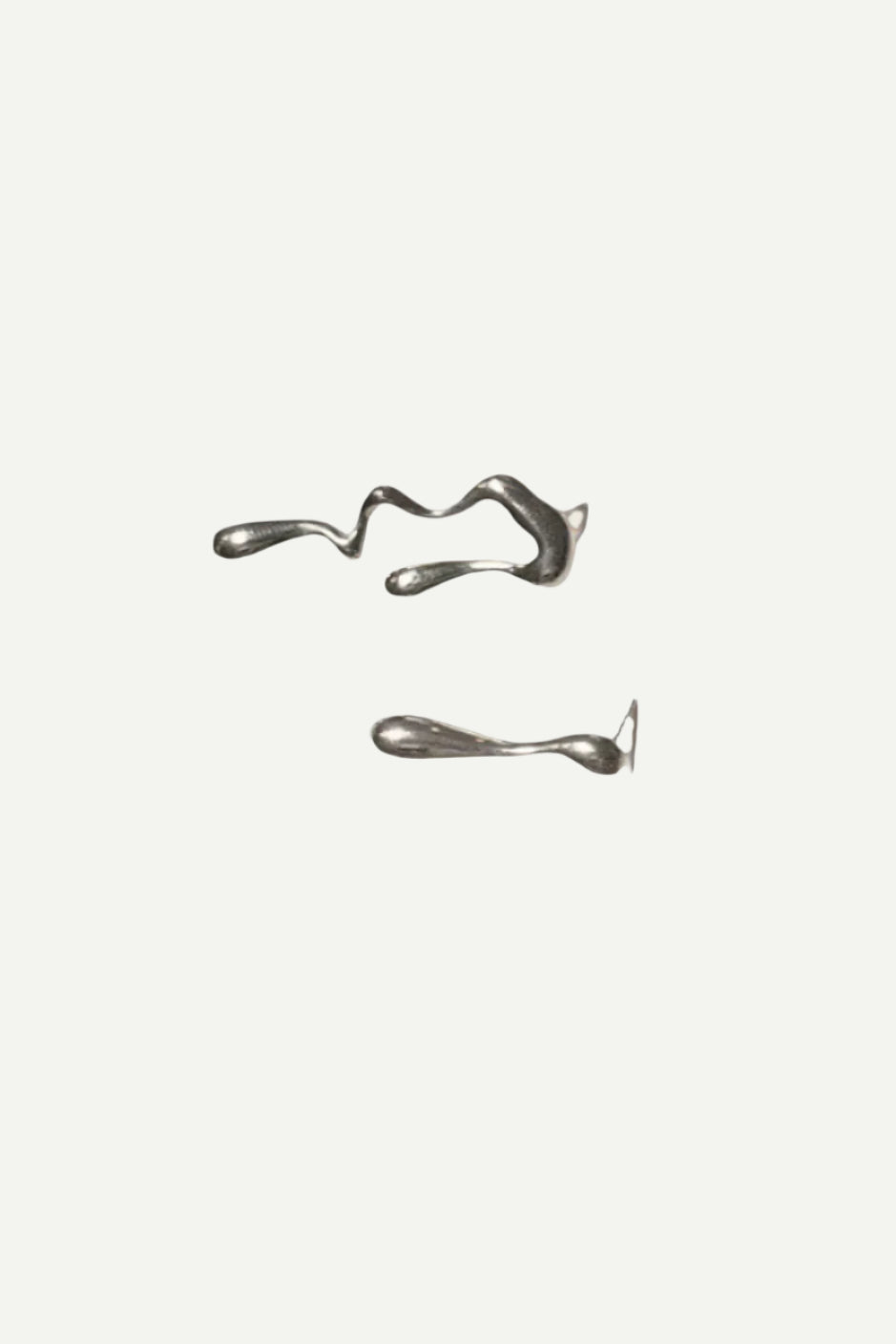 Minimal stainless steel stud earrings displayed on a neutral background.